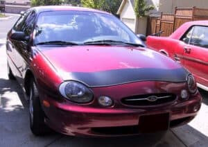 1996 red Ford Taurus with a black magnetic car bra